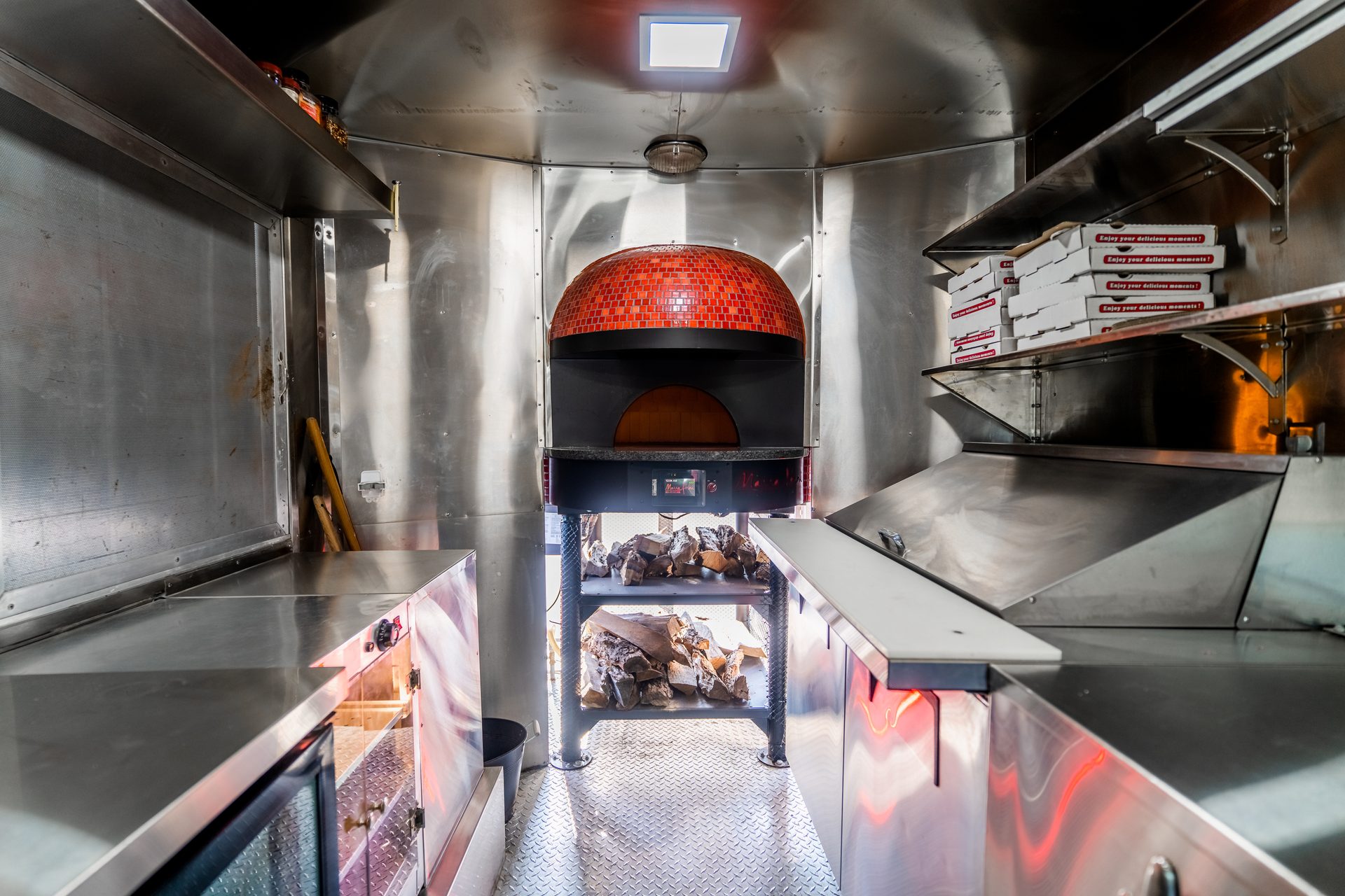 Interior overview — brick oven, stainless counters, pizza boxes