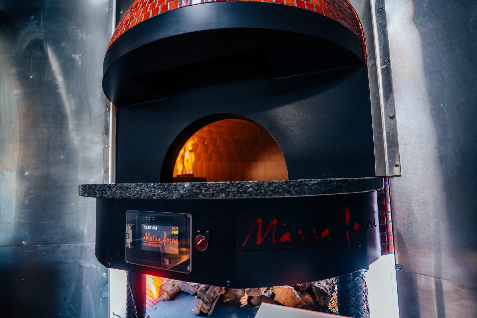Wood-fired brick oven with flames visible inside