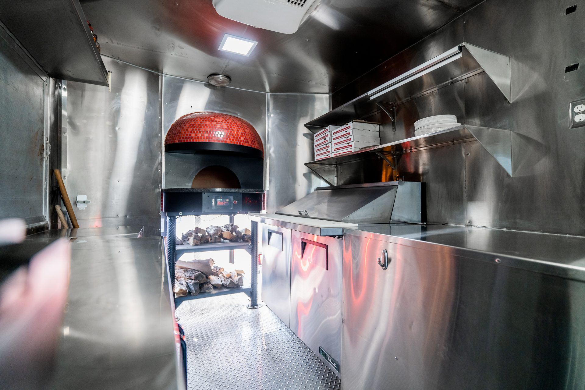 Interior with red brick oven and stainless counters