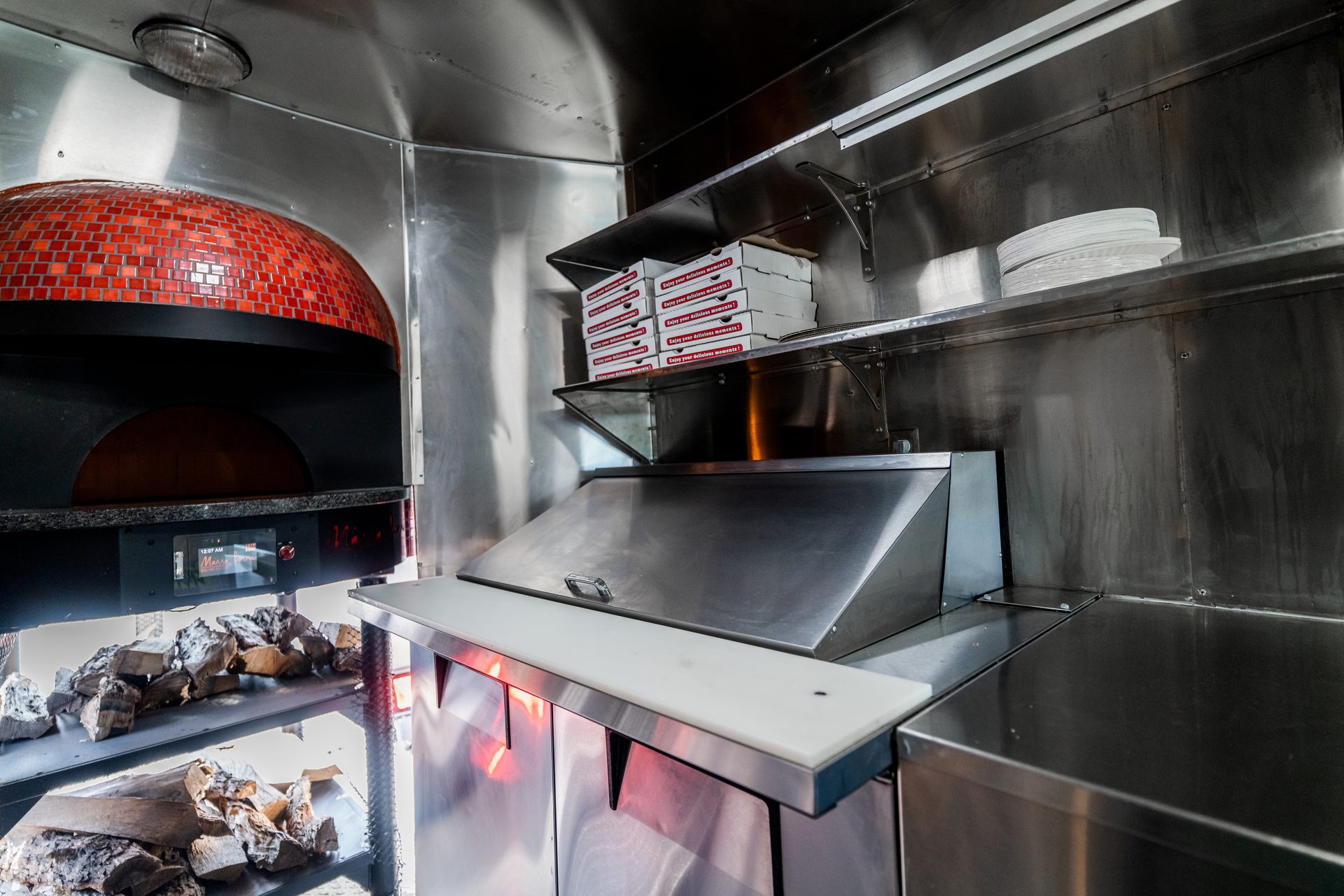 Interior showing brick oven, pizza boxes, and counters
