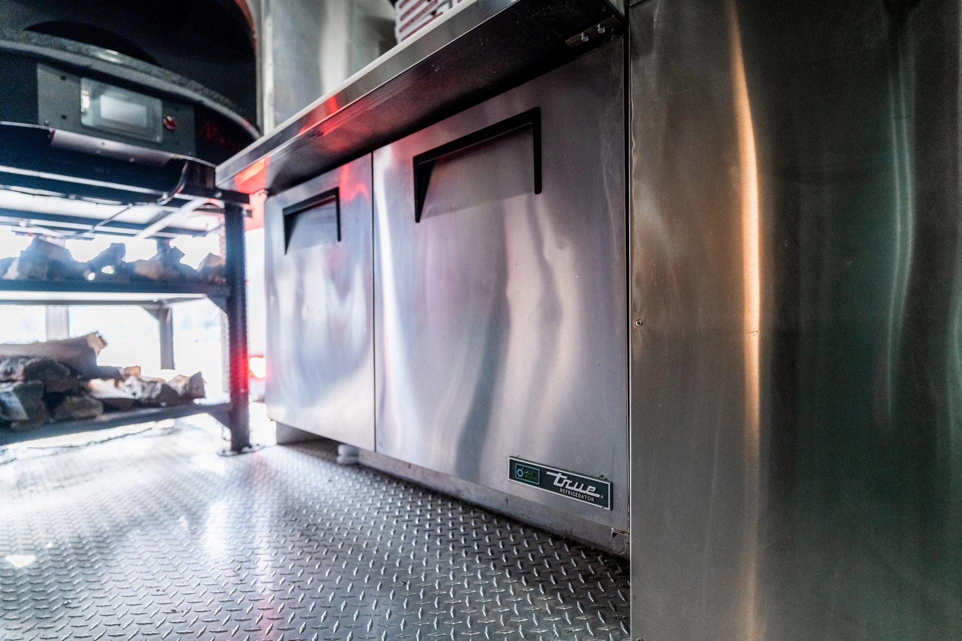 Stainless counter, refrigerator, and firewood storage