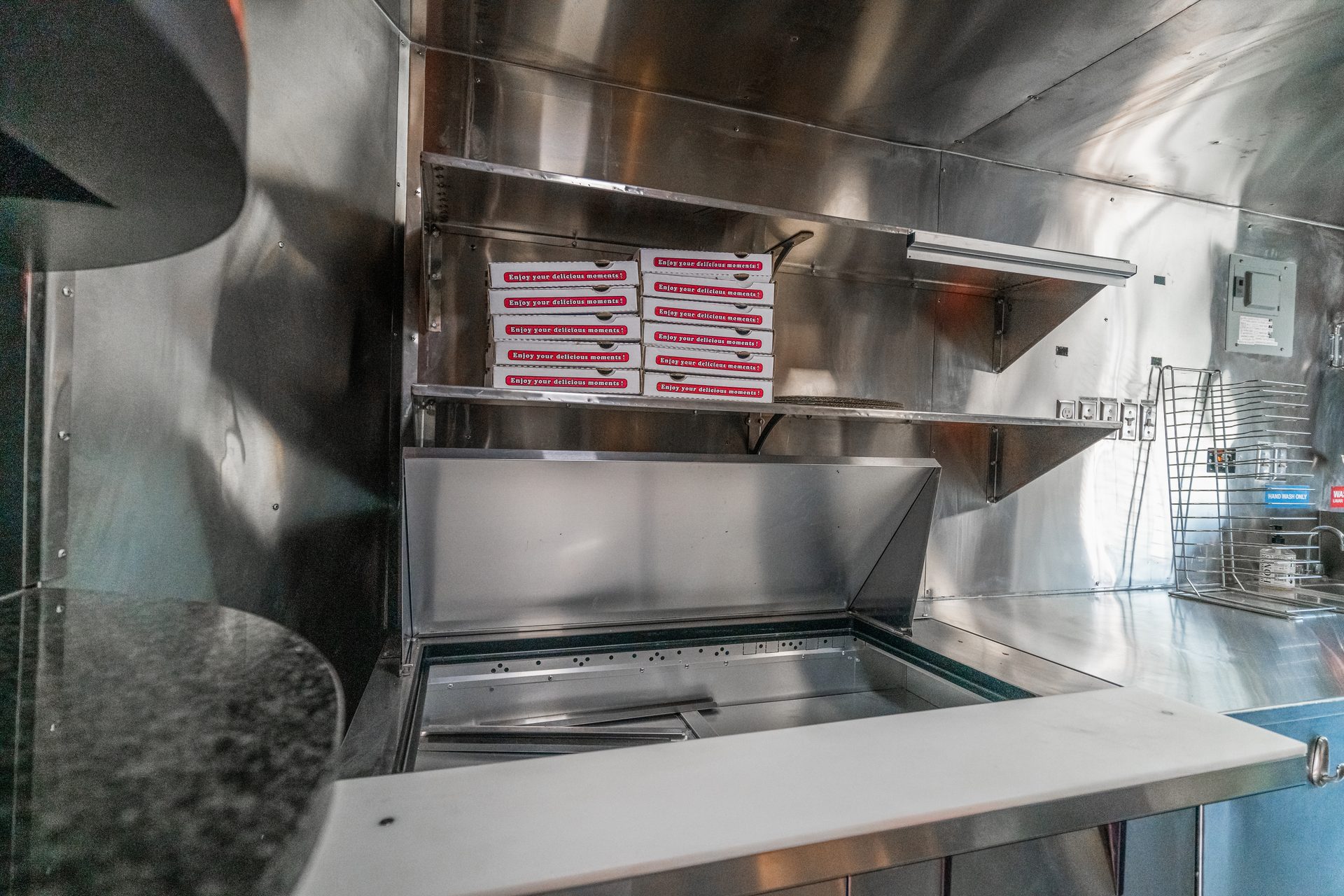 Interior with stainless surfaces, shelves, and pizza boxes