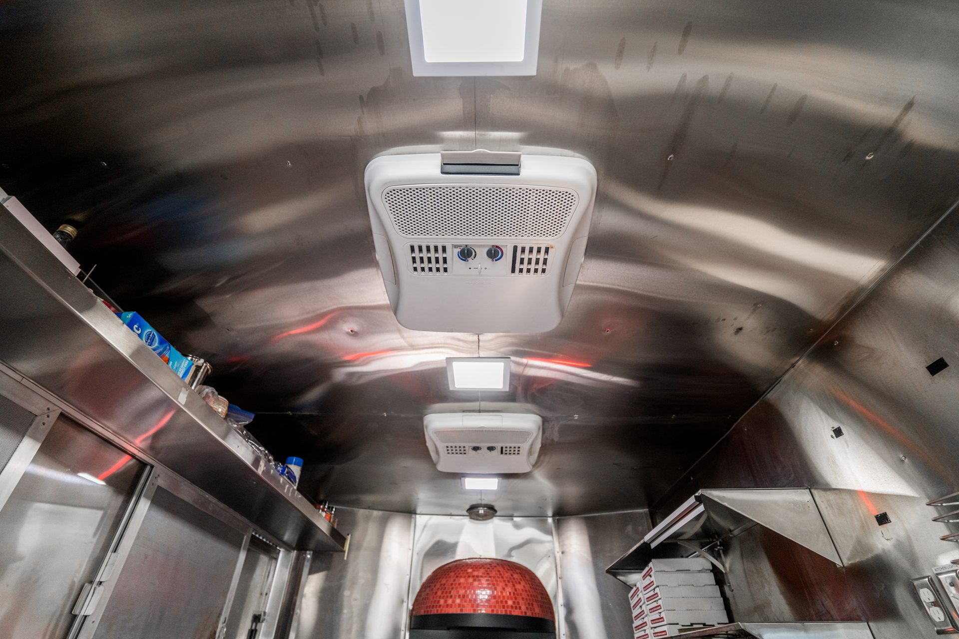 Interior with brick oven, shelving, and ceiling-mounted AC units