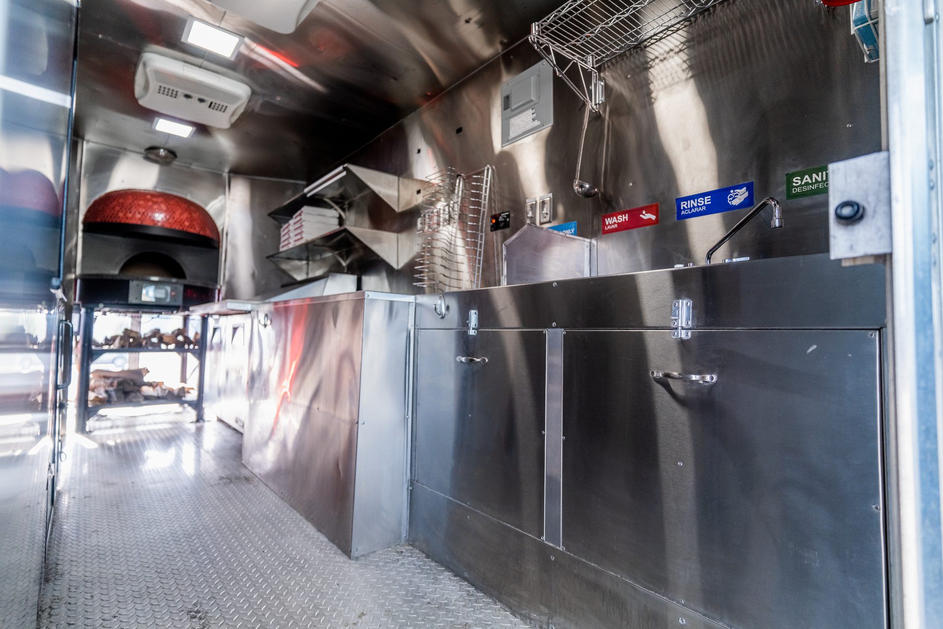 Interior with brick oven, stainless counters, and sinks