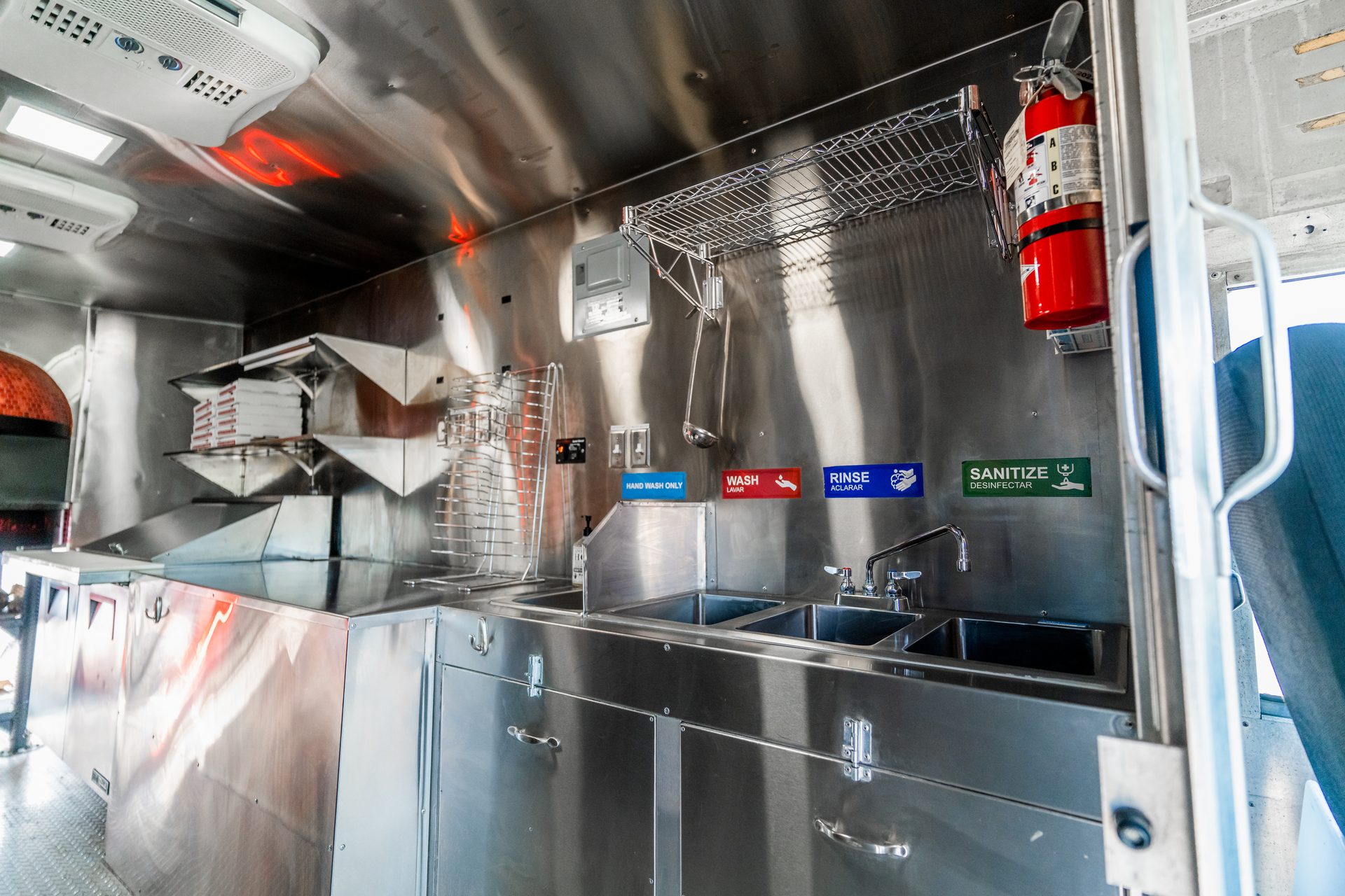Kitchen with stainless counters, multiple sinks, and fire extinguisher