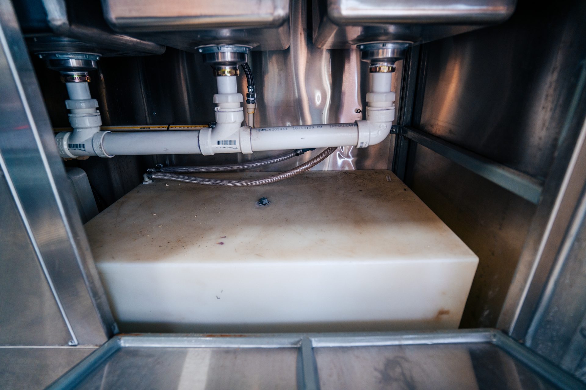 Plumbing and water tank under the sinks